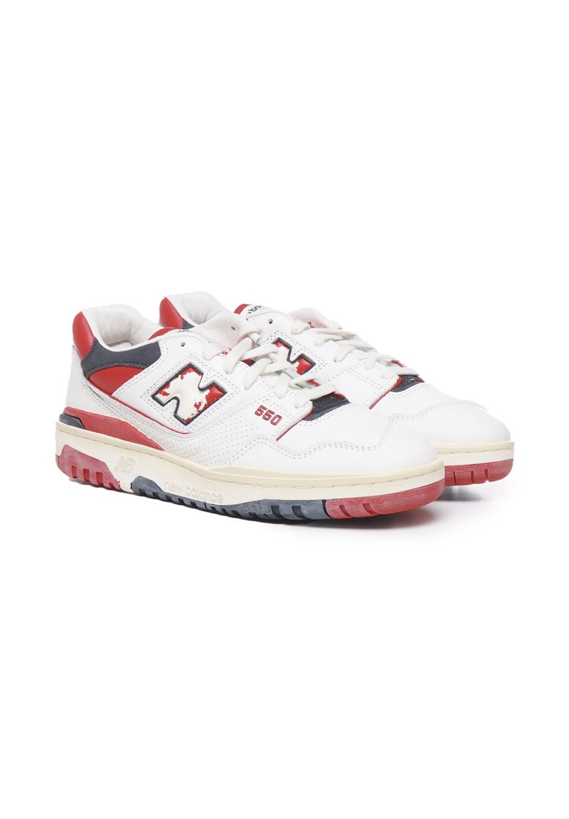 Weiße Leder-Sneaker mit roten und navyblauen Akzenten, die über Lochdetails, eine weiße Zwischensohle und eine Gummisohle mit gefärbten Stollen verfügen.