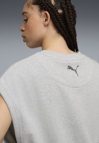 Gray sweatshirt with short sleeves, featuring a round neckline and a small black Puma logo on the back. Soft, textured fabric.