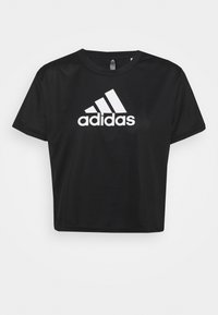 Černé zkrácené tričko z hladké látky s velkým bílým logem Adidas na přední straně. Kulatý výstřih a krátké rukávy.