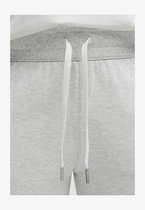 Lichtgrijze joggers met een ribbelband, voorzien van witte trekkoorden met metalen uiteinden en een zachte, gestructureerde stof.