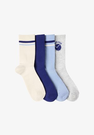 Sats med fyra par strumpor i krämfärgad, mörkblå, ljusblå och grå. Varje par har en ribbad textur, med kontrasterande ränder och tryckt logotyp.