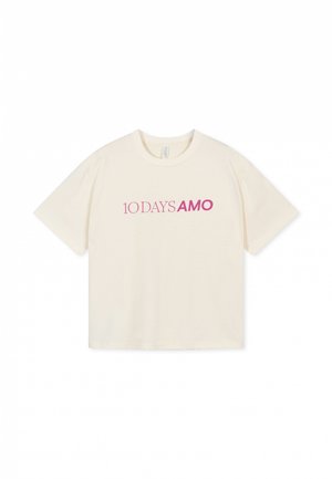 Crème-kleurig katoenen t-shirt met korte mouwen en een ronde hals, met roze tekst die "10 DAYS AMO" op de voorkant leest.