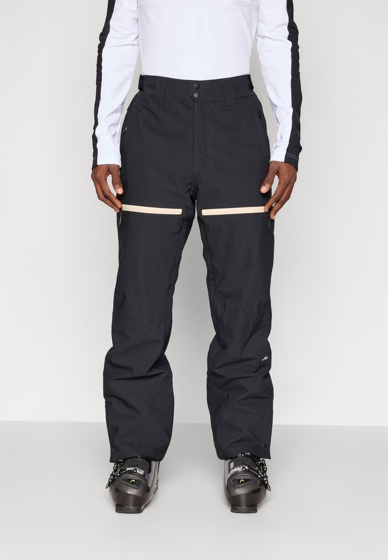 Fekete vízálló hó nadrág, tapered fazonnal, két vízszintes bézs cipzáras zsebbel és megerősített szegélyekkel a tartósság érdekében.