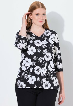 Top nero con motivo floreale bianco, presenta un collo a V, maniche a tre quarti e una vestibilità comoda. Tessuto morbido e testurizzato.