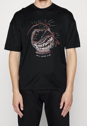 Musta t-paita, jossa on kuva punaisilla käsillä pidettävästä kristallipallosta ja tekstit "Emporio Armani" ja "Love Destiny Fate" alla.