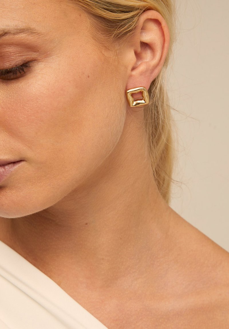 Boucles d'oreilles carrées en ton or avec une finition polie, présentant un accent rectangulaire ouvert, présentées sur un fond neutre.