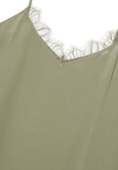 Camisole vert olive avec une texture douce, présentant un décolleté en V orné de délicates bordures en dentelle effilochée.