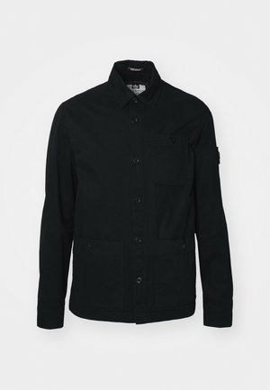 Črna, dolgoslečna majica-jaket iz bombaža, z gumbom spredaj, dvema velikima sprednjima žepoma in enim majhnim žepom na prsih.