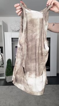 Top sem mangas, em tons castanhos e bege com efeito tie-dye, feito de tecido leve, apresentando laterais drapeadas e um caimento descontraído. Destaques de textura e padrões notáveis.