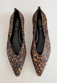 Leopardprint spidse flade sko med overdel i sort og brun kunstpels, sort indvendig foring og en lille bagløjfe for nem påtagning.