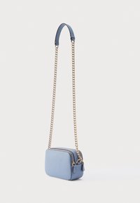 Φωτεινό γαλάζιο τσαντάκι χιαστί με ορθογώνιο σχήμα, υφή εξωτερικά και αλυσίδα ιμάντα. Διαθέτει φερμουάρ κλεισίματος και δερμάτινες λεπτομέρειες.