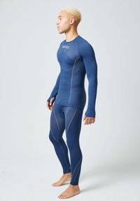 Conjunto de capa base atlética en color navy con mangas largas y un diseño ajustado. Textura suave con sutiles acentos de costura blanca.