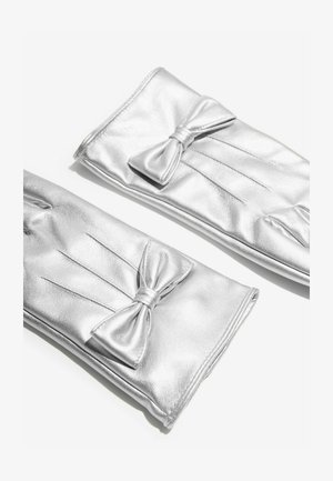 Stříbrné kožené rukavice s hladkým povrchem, zdobené mašlí a záhyby. Design je elegantní a štíhlý.