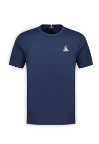 Navy blue cotton t-shirt with short sleeves, round neck, and a small logo featuring a rooster and tricolor accents on the collar.