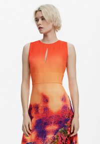 Ärmelloses oranges Kleid mit einem Ausschnitt in Tropfenform, das in ein farbenfrohes Blumenmuster in Lila und Rosa übergeht, aus glattem Stoff gefertigt.