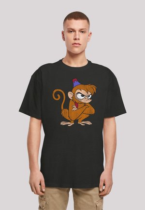 Black cotton t-shirt featuring a cartoonish brown monkey graphic with a blue and red hat, arms crossed, and an exaggerated expression.