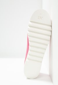 Baskets en suede rose avec une semelle en caoutchouc blanc dotée de rainures texturées et d'une pointe arrondie. Étiquette de taille "37" visible sur la semelle.