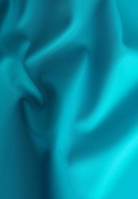Tissu turquoise avec une texture lisse et soyeuse, présentant de douces plis et une couleur uniforme. Aucun motif ou texture n'est visible.
