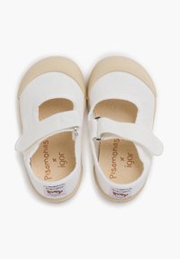Zapatillas Mary Jane de lienzo blanco con suela de goma beige, que cuentan con una correa de velcro, etiqueta de logo bordada y un diseño de puntera redonda.