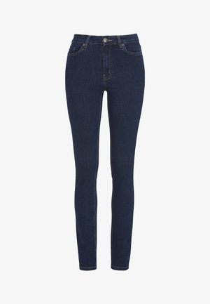 Kapeat farkut tummasta denimistä, joissa on hyvin istuva siluetti. Ominaisuuksia ovat keski-nostoinen vyötärö, etutaskut ja erottuva ompelu. Klassinen muotoilu.