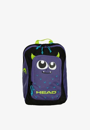 Sac à dos violet et noir avec visage de monstre dessin animé, cornes vertes, tirettes de fermeture éclair bleues, et logo "HEAD" sur la poche avant.