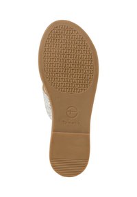 Sole of a shoe featuring a smooth, tan rubber base with a grid pattern for traction. Includes brand logo and size marking.