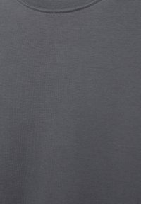 Pull ras du cou gris en tissu mélangé de coton. Texture douce avec une finition lisse et un design simple et minimal. Aucun motif ni accent visible.