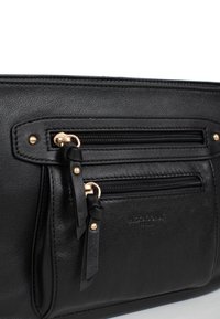 Borsa in pelle nera con due tasche con zip e hardware dorato. Presenta una superficie testurizzata e un logo in rilievo discreto sul davanti.