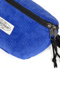 POCHETTO A ZIP IN CORDURO' BLU CON ZIP NERA E ETICHETTA BIANCA DEL MARCHIO EASTPAK LATERALE.