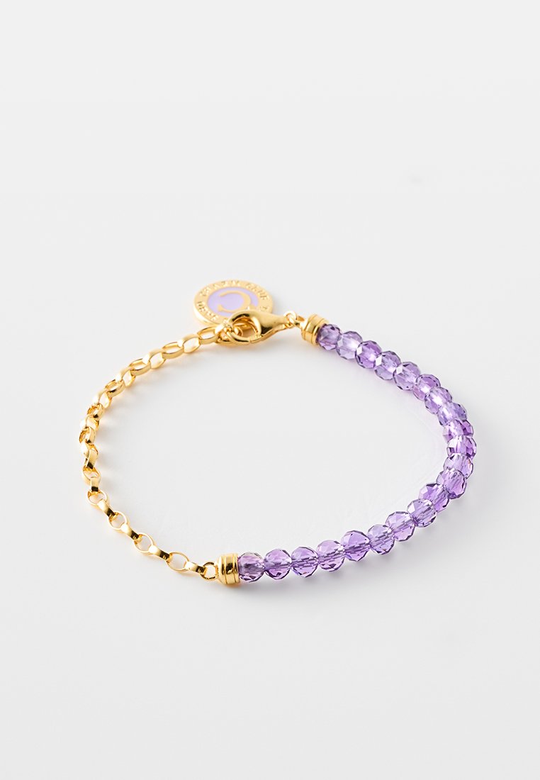 Goldene Kettenarmband mit einer Reihe von lila Kristallperlen und einem runden goldenen Charm. Verfügt über einen sicheren Verschluss und ein insgesamt schimmerndes Design.