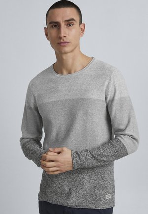 Grå langermet skjorte med tekstur, med en ensfarget overdel og mønstrede ermer. Rund hals og subtil merking på nederste kant.