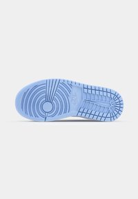 Semelle de chaussure Nike bleu clair avec des motifs de rainures circulaires et linéaires, logo Nike visible près du centre.