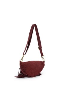 Rode suède schoudertas met halvemaanvorm, voorzien van franjes en een smalle verstelbare riem. Goudkleurige hardware complementeert het ontwerp.