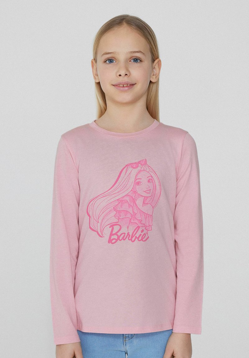 Růžová košile s dlouhým rukávem, na které je karikatura dívky s dlouhými vlasy a text "Barbie" v růžové barvě na spodní části.