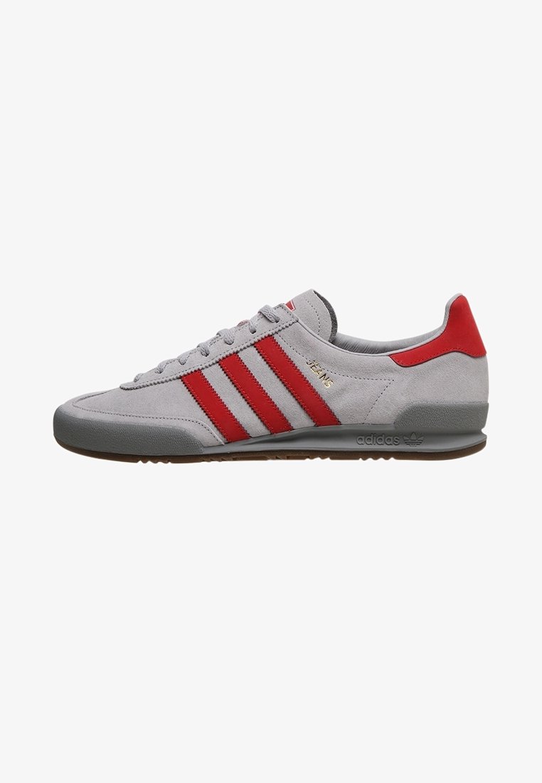 Gray suede athletic shoe with red accents and three red stripes. Features a round toe, textured rubber sole, and minimal branding.