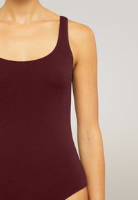 Burgundy baddräkt med scoop-nacke och tunna axelremmar. Slät tyg med en åtsittande, sömlös design. Enkelsömskonstruktion.