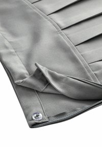 Tissu gris avec un design plissé, fermeture à glissière et un bouton transparent. Le matériau a une texture lisse avec un léger éclat.