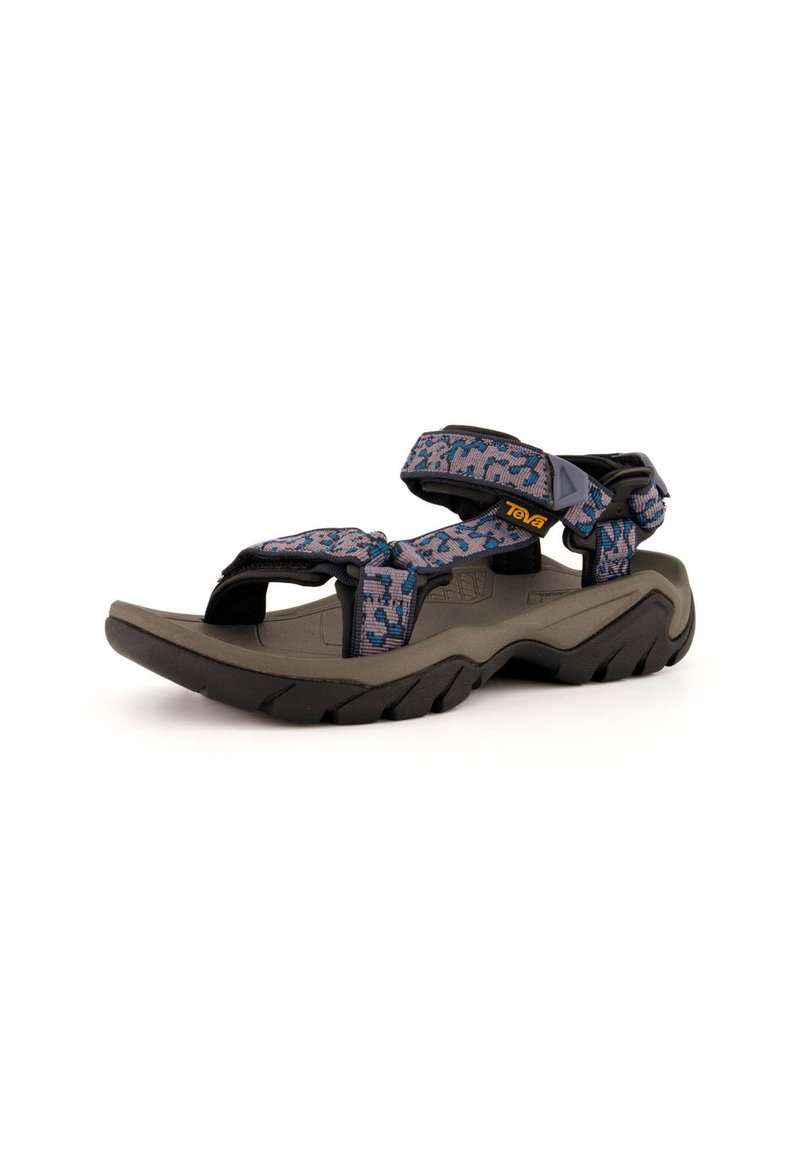 Teva-sandaalit, joissa on tummanharmaa kumipohja, moniväriset kuviolliset hihnat, säädettävät tarranauhakohdat ja muotoiltu jalkapohjan design.