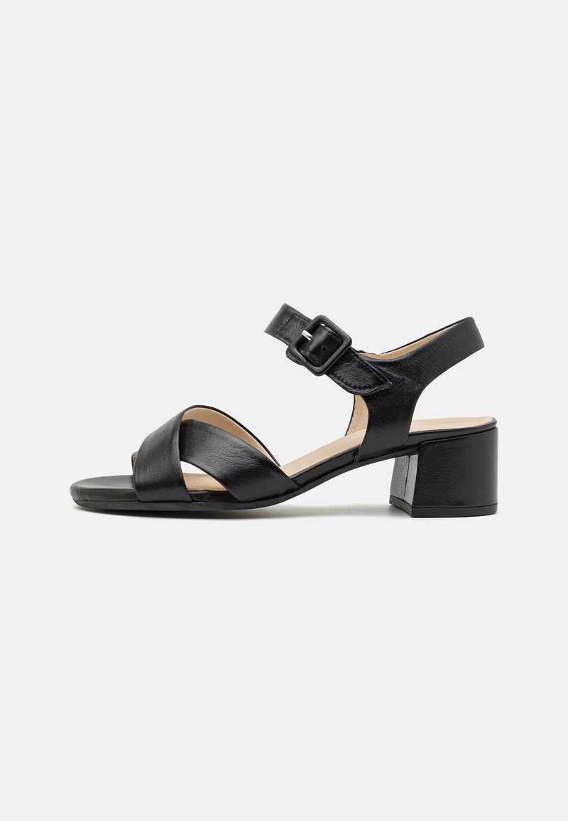 Sandale en cuir noir avec petit talon bloc, bout ouvert, brides croisées et bride de cheville réglable avec boucle, vue de côté.