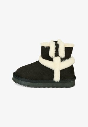 Stivale alla caviglia in suede nero con fodera in shearling bianco, caratterizzato da un logo bianco e suola in gomma a contrasto. Altezza corta con punta arrotondata.