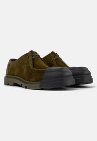 Scarpe di camoscio marrone con punta in gomma nera, design arrotondato, lacci grigi e suola testurizzata. Adatte per un look casual.