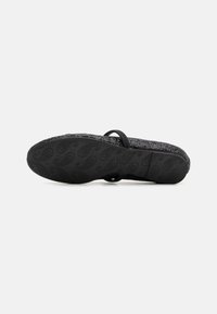 Sandalias negras con una plantilla texturizada, suela de goma con un patrón de paisley, y una elegante correa negra en la parte superior.