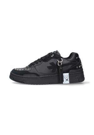 Sneaker nero low-top con chiusura frontale con lacci, punta e tallone con borchie, logo laterale e piccola etichetta appesa vicino ai lacci.