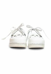 Witte klompen met decoratieve uitsparingen en witte lintveters. Beschikt over een chunky zool en gestikte details langs de randen.