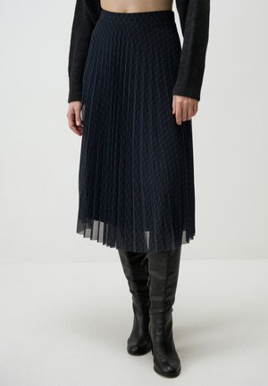 Pleated navy skirt made of lightweight fabric with a diamond pattern. Features an elastic waistband and a flowy, layered design.