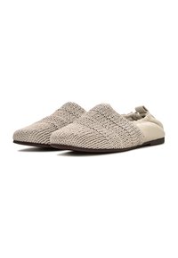 Zapatos beige sin cordones con parte superior de tela tejida texturizada y talón de cuero suave. Suela plana con diseño de tracción mínima.