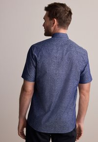 Lühikeste varrukatega särk tumel sinisest kangast lillemustriga. Omaduseks on traditsiooniline krae ja sirge äär koos sileda tekstuuriga.