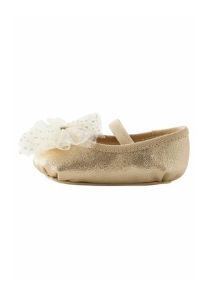 Soft gold baby shoe with elastic ankle strap and large white tulle bow with gold star accents on front.