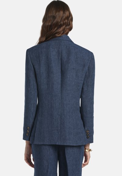 Dark blue blazer made of textured fabric, featuring a notched lapel, back vent, and four button accents on each sleeve.