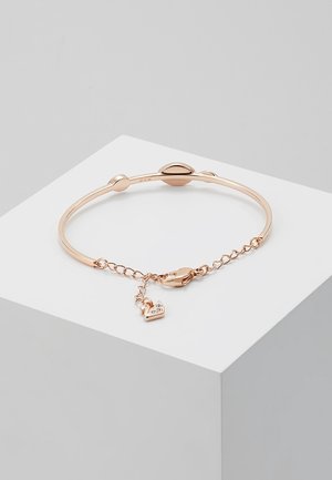Bracelet en or rose avec un bracelet fin, des accents ovales, une fermeture à chaîne et un petit pendentif en forme de cœur avec des cristaux incrustés.